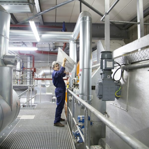 Engineer removing cover from equipment in power station