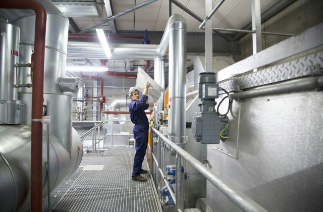 Engineer removing cover from equipment in power station